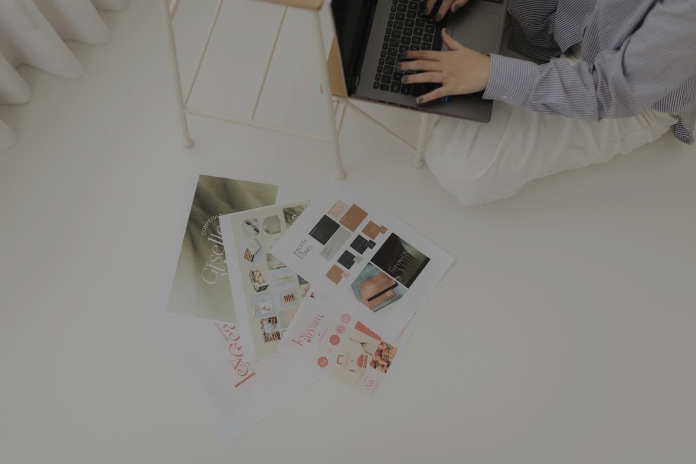 Mesa de trabalho com notebook e materiais de design da Peres Design