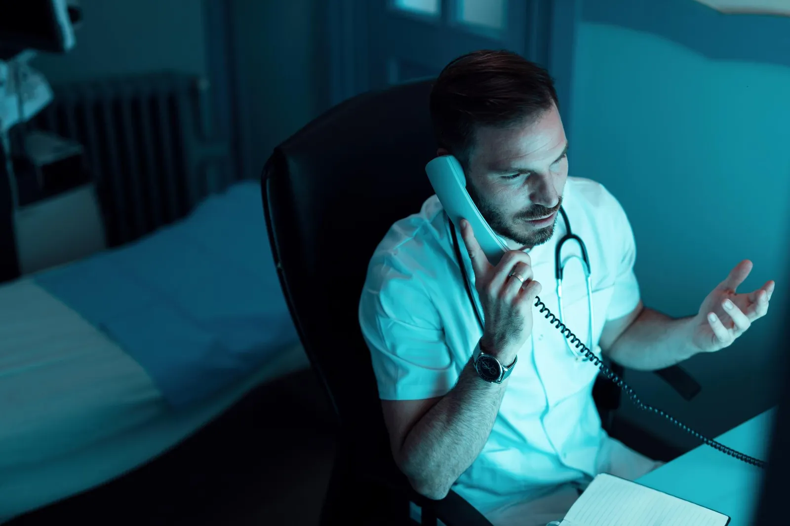 Profissional de saúde ao telefone durante plantão noturno no hospital
