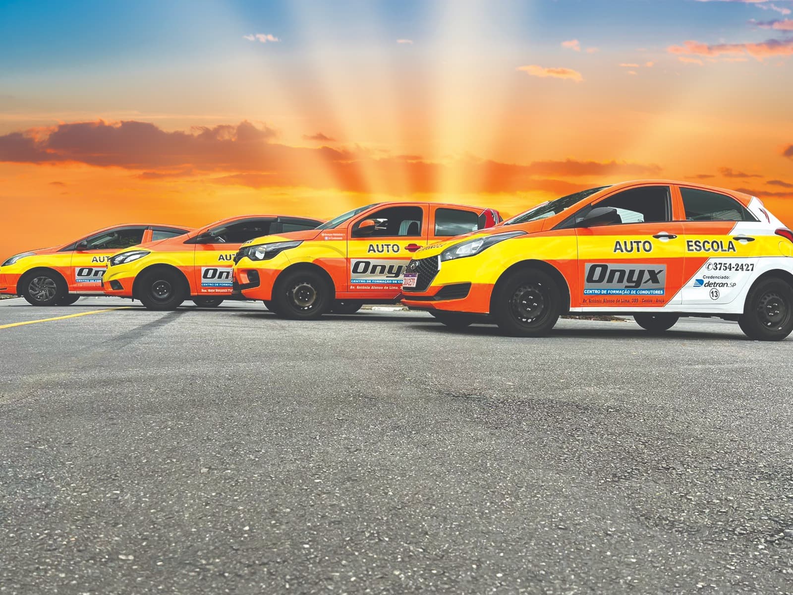 Frota de veículos da Autoescola Onyx enfileirada ao pôr do sol