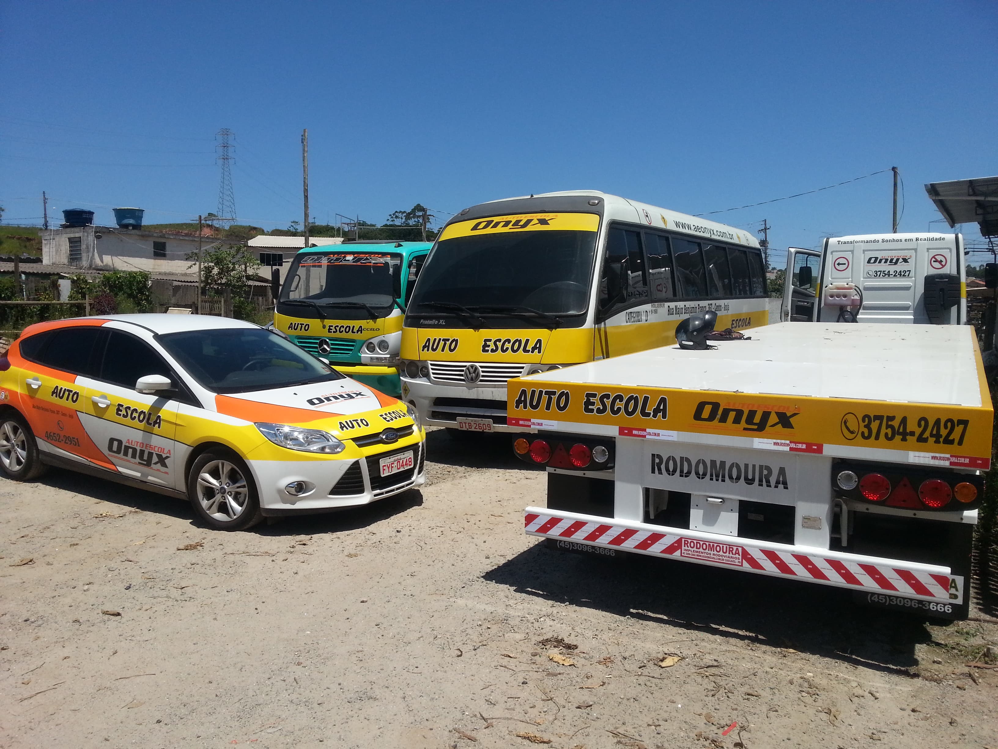 Pátio da Autoescola Onyx com carro, micro-ônibus, caminhões e carreta de treinamento